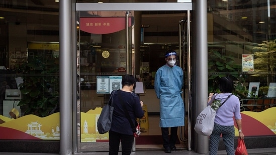 Covid In Macau A security guard controls the entrance to a bank in the Fai Chi Kei area.(Bloomberg)