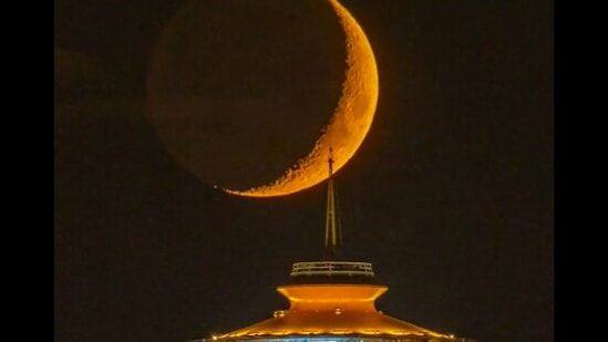 The image, taken from the viral Twitter video, shows the Moon setting behind Seattle's Space Needle.(Twitter/@sigmas)