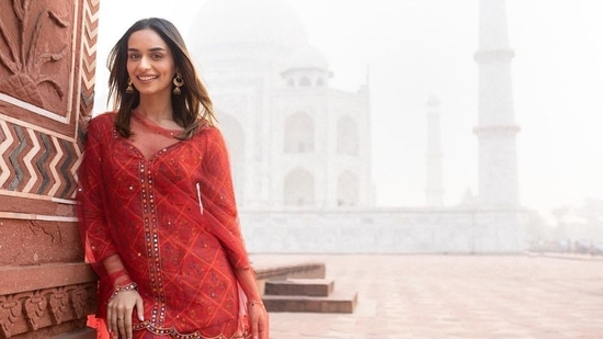 Manushi Chhillar posed like a tourist on a green bench inside the premises of Taj Mahal with the structure in the backdrop.(Instagram/@manushi_chhillar)