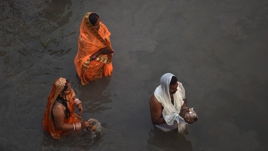 Devotees perform Chhath Puja rituals in the Yamuna River at Kalindi Kunj on the occasion of Chhath puja in Noida. (HT Photo/Sunil Ghosh)
