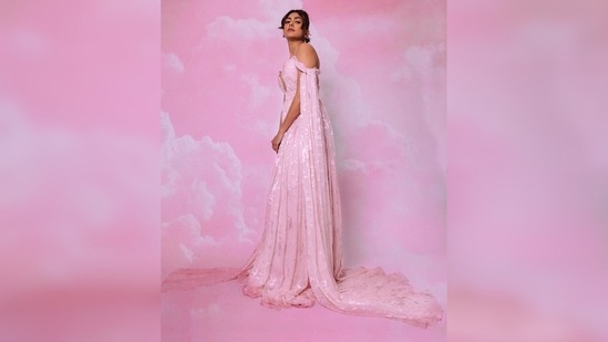 Mrunal Thakur's long flowy pleated gown features an intense plunging neckline with arm floor-sweeping trails.(Instagram/@mrunalthakur)