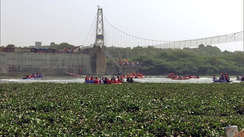 A rescue operation underway after a cable bridge collapsed in the Machchhu river, in Morbi on Monday. (ANI Photo)