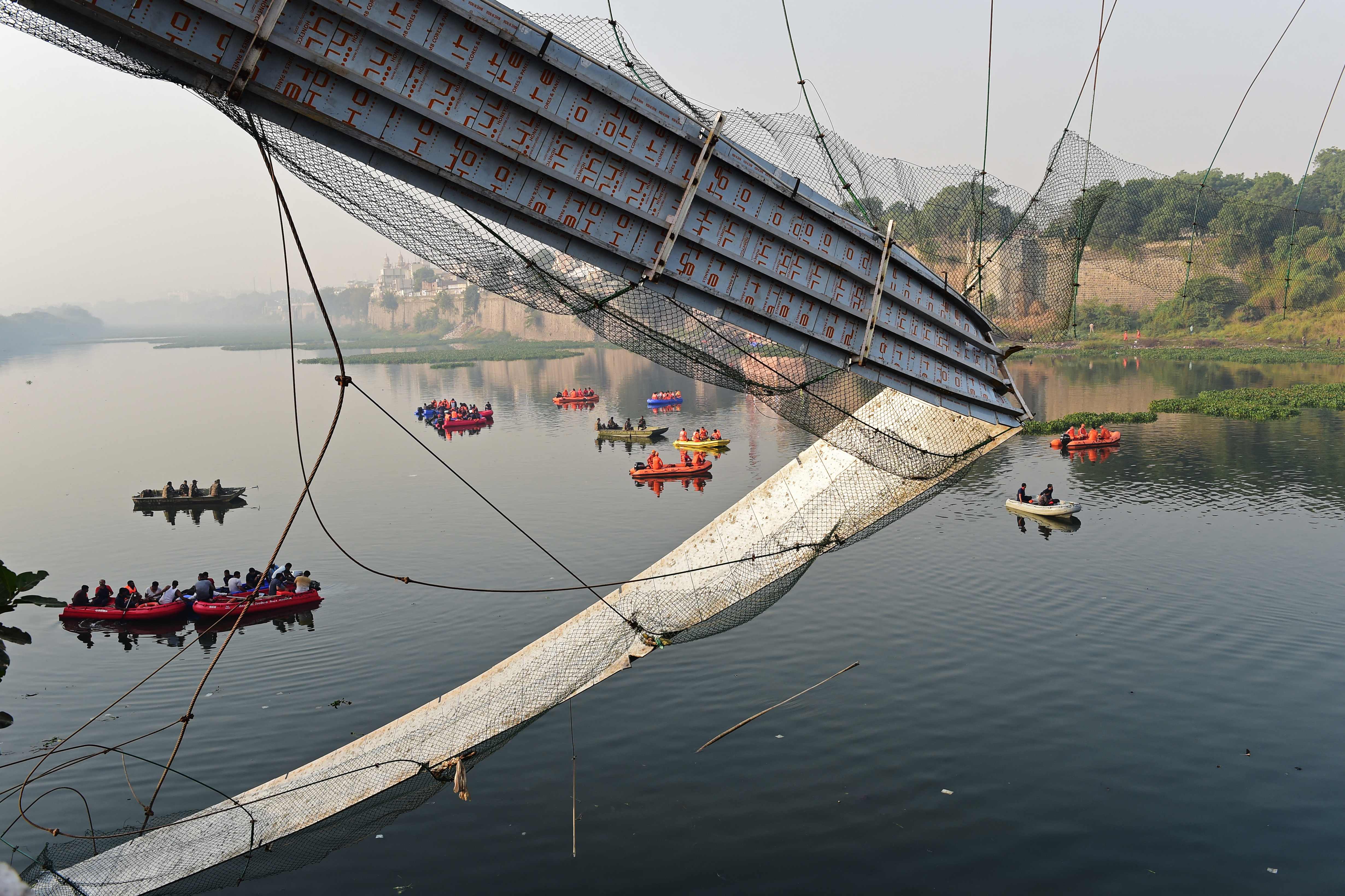Rescue personnel conduct search operations after a bridge across the river Machchhu collapsed at Morbi in Gujarat. (AFP) Rescue personnel conduct search operations after a bridge across the river Machchhu collapsed at Morbi in Gujarat. (AFP)