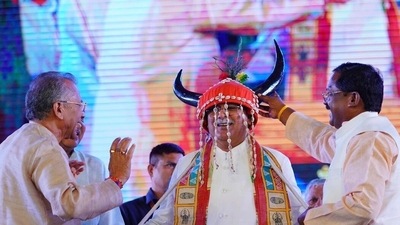 Raipur, Nov 01 (ANI): Chhattisgarh Chief Minister Bhupesh Baghel wearing a traditional attire tries his hands on playing drum at the inauguration of the third edition of National Tribe Dance Festival, in Raipur on Tuesday. (ANI Photo) (ANI) Raipur, Nov 01 (ANI): Chhattisgarh Chief Minister Bhupesh Baghel wearing a traditional attire tries his hands on playing drum at the inauguration of the third edition of National Tribe Dance Festival, in Raipur on Tuesday. (ANI Photo) (ANI)