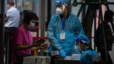 Covid In Macau: A pedestrians checks her health code before testing. (Bloomberg)
