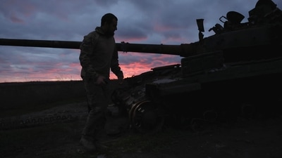 Russia-Ukraine War: A Ukrainian serviceman walks near a destroyed tank at sunset. (Reuters)