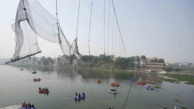 Rescuers on boats search in the Machchu river next to a cable bridge that collapsed on Sunday in Morbi town of western state Gujarat, India, on Tuesday. (AP) Rescuers on boats search in the Machchu river next to a cable bridge that collapsed on Sunday in Morbi town of western state Gujarat, India, on Tuesday. (AP)