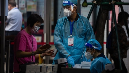 Covid In Macau: A pedestrians checks her health code before testing.