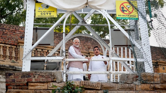 Prime Minister Narendra Modi with Gujarat home minister Harsh Sanghavi at the site to take stock of the situation.(PTI)