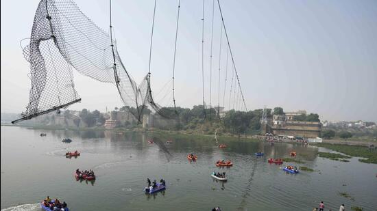 Rescuers on boats search in the Machchu river next to a cable bridge that collapsed on Sunday in Morbi town of western state Gujarat, India, on Tuesday. (AP)