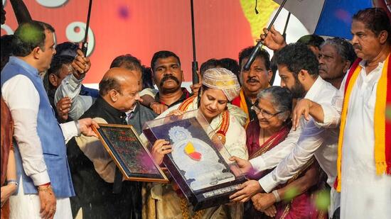Karnataka chief minister Basavaraj Bommai felicitates late actor Puneeth Rajkumar’s wife Ashwini during the 67th Kannada Rajyotsava celebrations, in Bengaluru. (PTI)