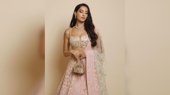 Nora Fatehi lehenga comes with a golden blouse featuring a plunging neckline and a matching dupatta.(Instagram/@norafatehi05)