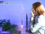 North Korea: A woman walks past a TV screen broadcasting a news report on North Korea firing a ballistic missile.