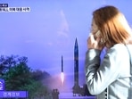 North Korea: A woman walks past a TV screen broadcasting a news report on North Korea firing a ballistic missile.