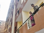 People from the economically weaker section pose for photos from the balcony of a newly constructed flat as part of the In-Situ Slum Rehabilitation project, at Kalkaji in New Delhi, Wednesday. Prime Minister Narendra Modi will hand over 3,024 newly constructed flats for the EWS on Wednesday. (PTI) People from the economically weaker section pose for photos from the balcony of a newly constructed flat as part of the In-Situ Slum Rehabilitation project, at Kalkaji in New Delhi, Wednesday. Prime Minister Narendra Modi will hand over 3,024 newly constructed flats for the EWS on Wednesday. (PTI)