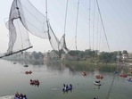 Rescuers on boats search in the Machchu river next to a cable bridge that collapsed on Sunday in Morbi town of western state Gujarat. Rescuers on boats search in the Machchu river next to a cable bridge that collapsed on Sunday in Morbi town of western state Gujarat.