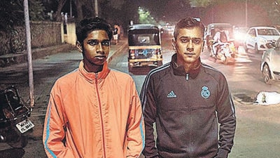 Ajay Adkar (in black) and his son Arjun cover a pothole (in the background) and alert citizens on Law College road. (Pratham Gokhale/HT Photo) Ajay Adkar (in black) and his son Arjun cover a pothole (in the background) and alert citizens on Law College road. (Pratham Gokhale/HT Photo)