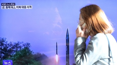 North Korea: A woman walks past a TV screen broadcasting a news report on North Korea firing a ballistic missile. (Reuters)