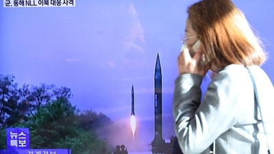 North Korea: A woman walks past a TV screen broadcasting a news report on North Korea firing a ballistic missile. (Reuters)
