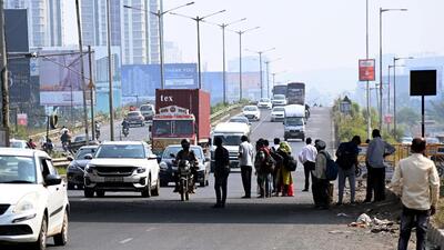 People crossing Pune-Bengaluru National Highway (NH) 4 near Bavdhan on Wednesday. (HT PHOTO)