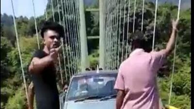 The video, which HT has seen, shows the driver struggling to cross the narrow suspension bridge meant for pedestrians as two men push the car towards the exit. (HT Photo)