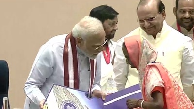 Prime Minister Narendra Modi hands over a key to an eligible beneficiary after inaugurating 3,024 newly constructed flats at Kalkaji, Delhi. (ANI)