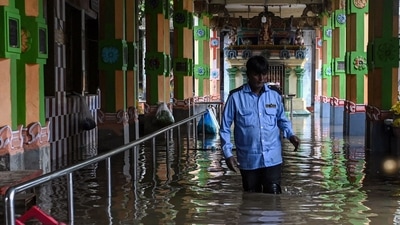 Security guard stand inside a flooded temple during a heavy monsoon rainfall in Chennai on Tuesday. (AFP) Security guard stand inside a flooded temple during a heavy monsoon rainfall in Chennai on Tuesday. (AFP)