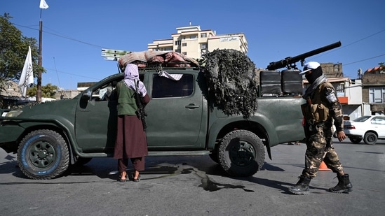 Afghanistan: Taliban fighters stand guard as they block a road near Kabul.(AFP)