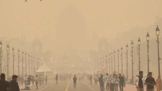 Commuters on Kartavya Path seen in a dense blanket of smog amid deteriorating air quality levels on Monday. (Sanjeev Verma/HT) )