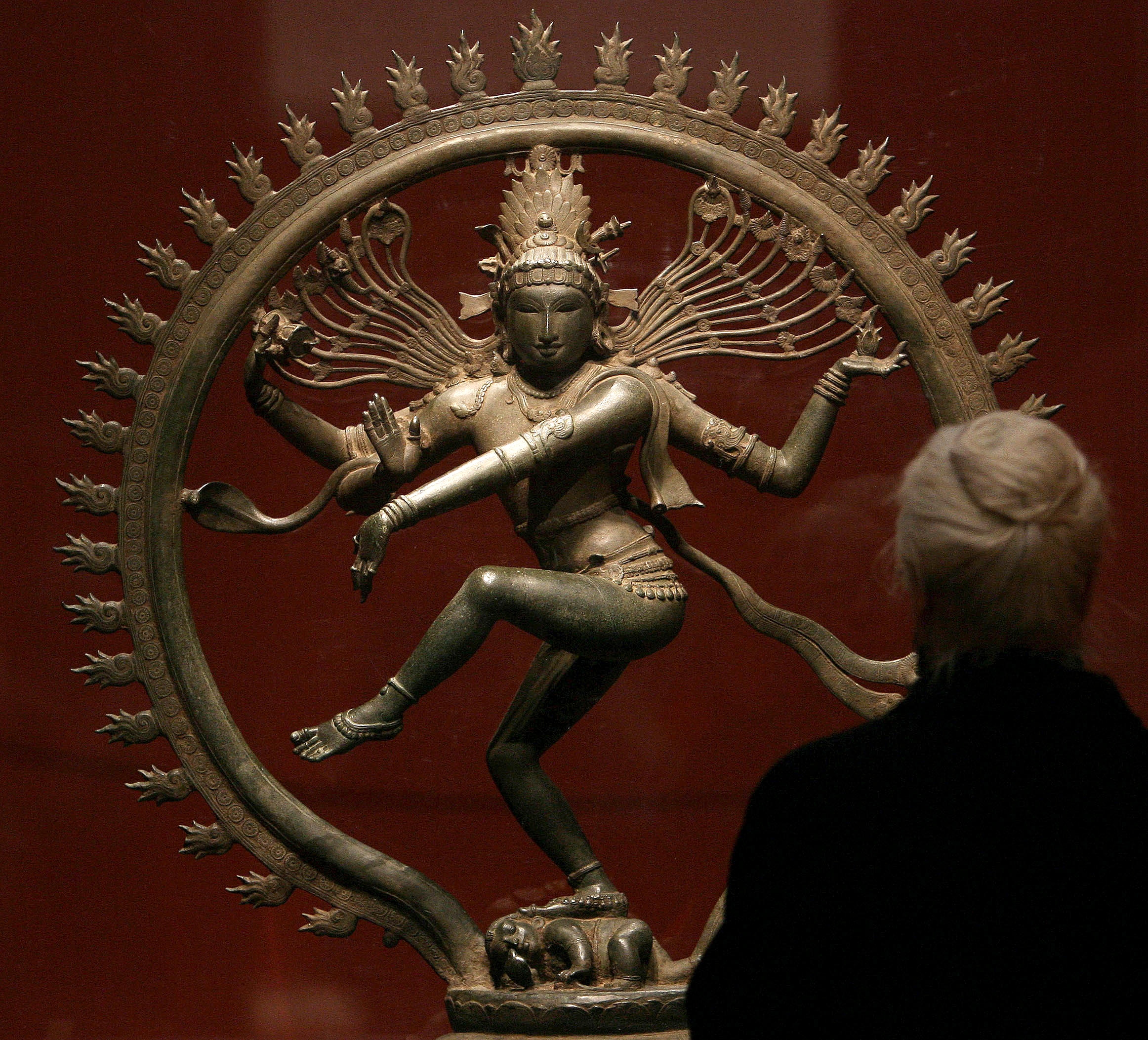 A visitor admires an Indian sculpture during an exhibition on Chola bronzes at the Royal Academy of Arts in central London. (Reuters)