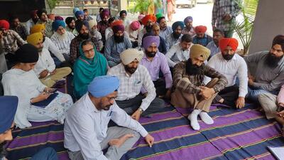 GNDEC employees protesting in front of the main office of the colllege in Ludhiana, seeking implementation of new pay scales. (HT PHOTO)
