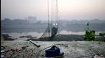 A shoe lies near a damaged suspension bridge after it collapsed on Sunday, in Morbi town in the western state of Gujarat (Reuters File Photo) A shoe lies near a damaged suspension bridge after it collapsed on Sunday, in Morbi town in the western state of Gujarat (Reuters File Photo)