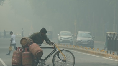 New Delhi: A worker carrying LPG cylinders on a bicycle crosses a road, shrouded in a thick layer of smog, in New Delhi, Friday, Nov. 4, 2022. (PTI)