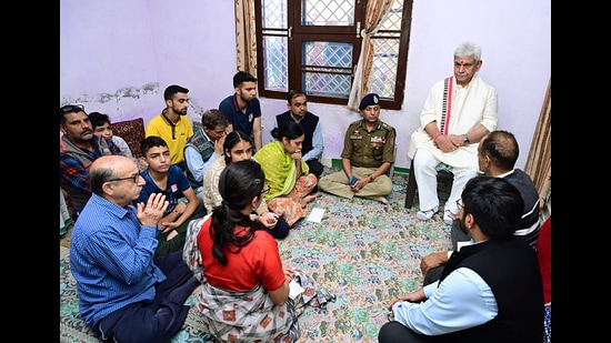 Jammu and Kashmir lieutenant governor Manoj Sinha meeting with the family members of slain Kashmiri Pandit Puran Krishan Bhat, at their residence, in Jammu on Friday. (ANI)