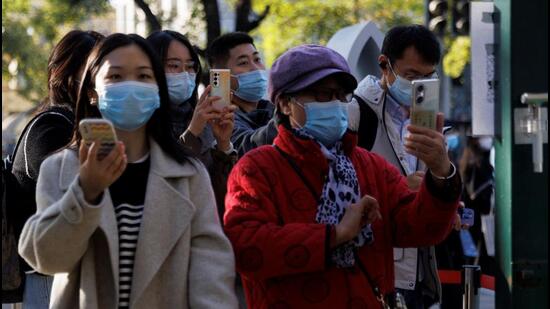 People scan their health codes before entering a fenced-off street as outbreaks of Covid-19 continue in Beijing, China, on Saturday. (REUTERS)