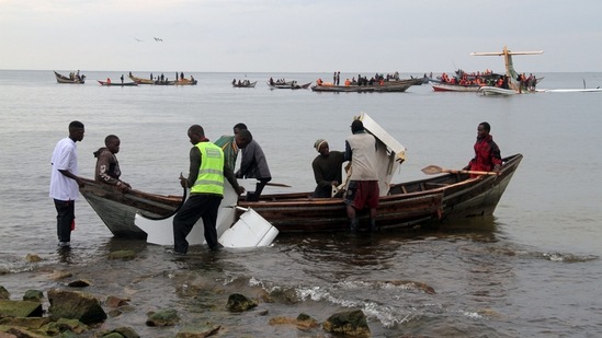 Rescuers carry debris as they search for survivors after a Precision Air flight that was carrying 43 people plunged into Lake Victoria as it attempted to land in the lakeside town of Bukoba, Tanzania on November 6, 2022. (AFP)