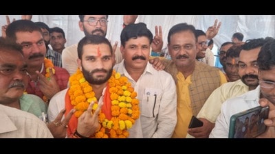 BJP’s Aman Giri showing victory mark after being elected in the bypolls on Sunday. (ht photo)