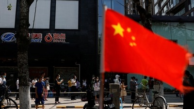 China-Taiwan: A China's flag flutters near people lining up to get tested at a makeshift nucleic acid testing site. (Reuters)