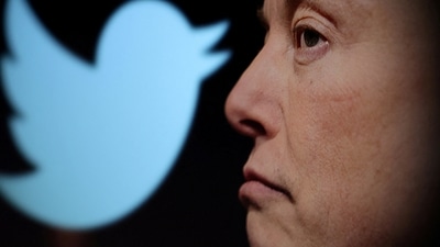 Twitter logo and a photo of Elon Musk are displayed through magnifier in this illustration. (Reuters)
