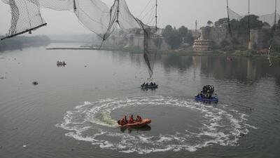 Rescuers on boats search in the Machchu river next to a cable bridge that collapsed on Sunday in Morbi. (AP) Rescuers on boats search in the Machchu river next to a cable bridge that collapsed on Sunday in Morbi. (AP)