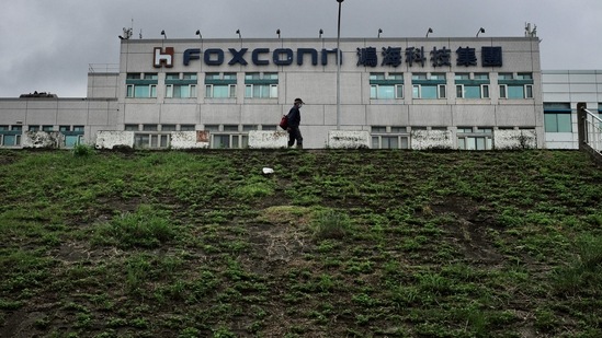 Covid In China: A man walking past the Foxconn headquarters.(AFP)