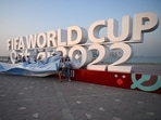 Argentina fans cheer in front of a FIFA World Cup sign in Doha