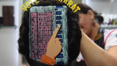 A beautician gives finishing touches as she paints 'Electronic Voting Machine' (EVM) on the hair of a woman ahead of the Gujarat assembly election, in Ahmedabad. (AFP) A beautician gives finishing touches as she paints 'Electronic Voting Machine' (EVM) on the hair of a woman ahead of the Gujarat assembly election, in Ahmedabad. (AFP)