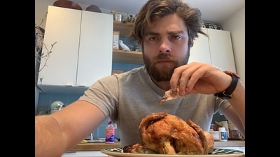 Alexander Tominsky eating rotisserie chicken. (Twitter/@AlexiconTom)