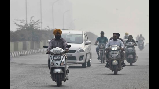Commuters make their way through the thick smog in Ludhiana on Tuesday. (Gurpreet SIngh/HT)