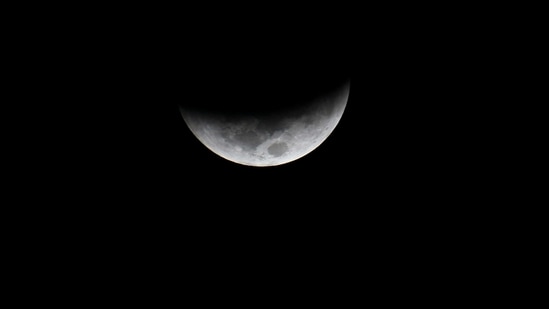 The moon is seen during a total lunar eclipse in Villa Nueva, Guatemala on November 8. Binoculars and telescopes will enhance viewing, provided the skies are clear.(AFP)