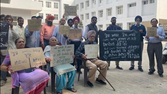 Elderly residents of Phase 3B1, Mohali, holding up placards to mark their protest against the state government’s move. (HT Photo)