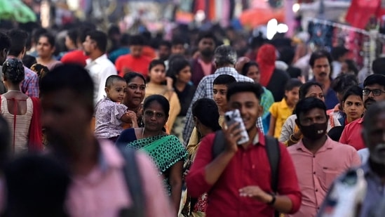 People walk through a crowded commercial street in Chennai.(AFP)