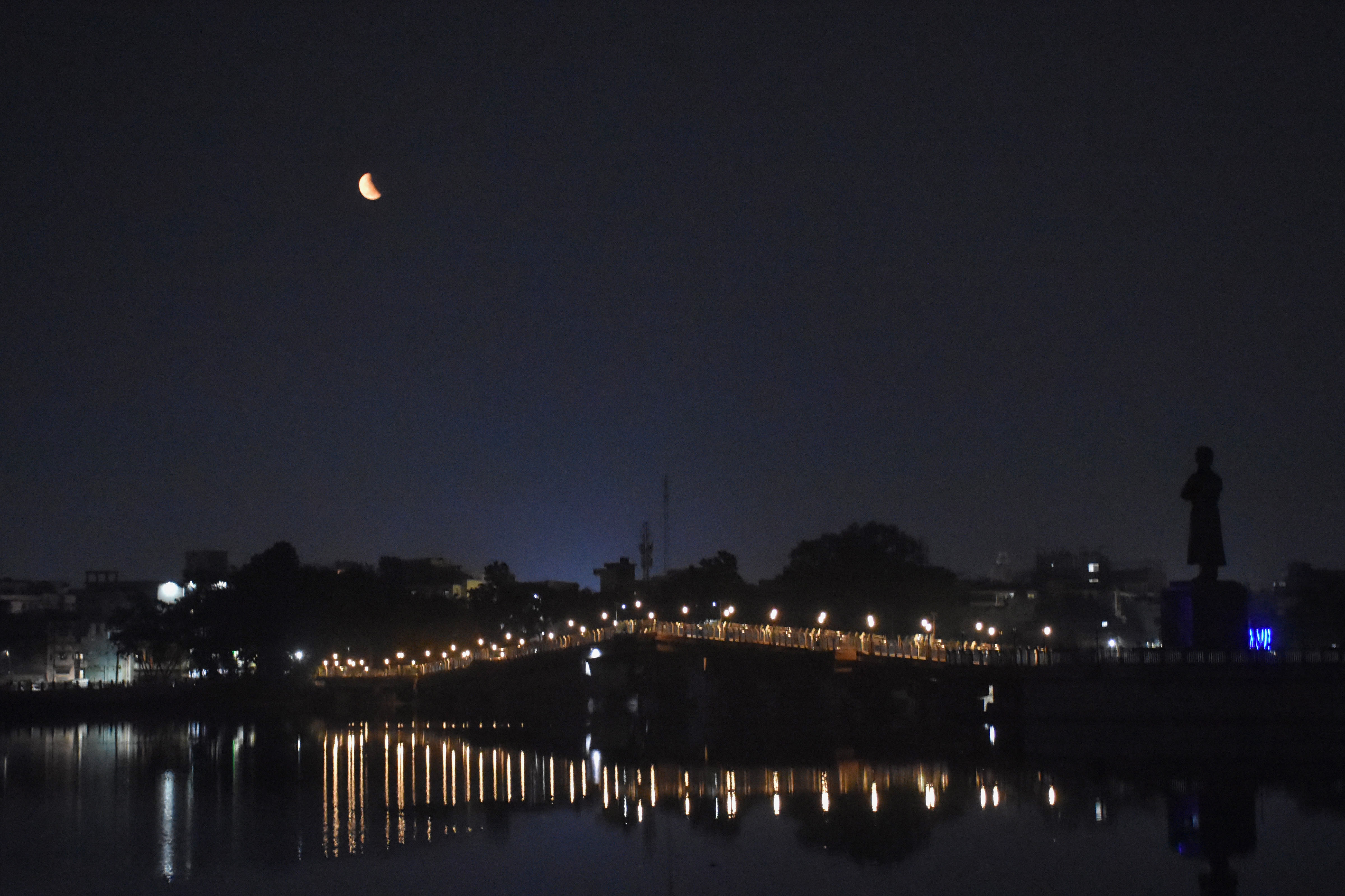 Ranchi: Moon partially covered by the earth's shadow during Lunar Eclipse in Ranchi Lake. (PTI) Ranchi: Moon partially covered by the earth's shadow during Lunar Eclipse in Ranchi Lake. (PTI)
