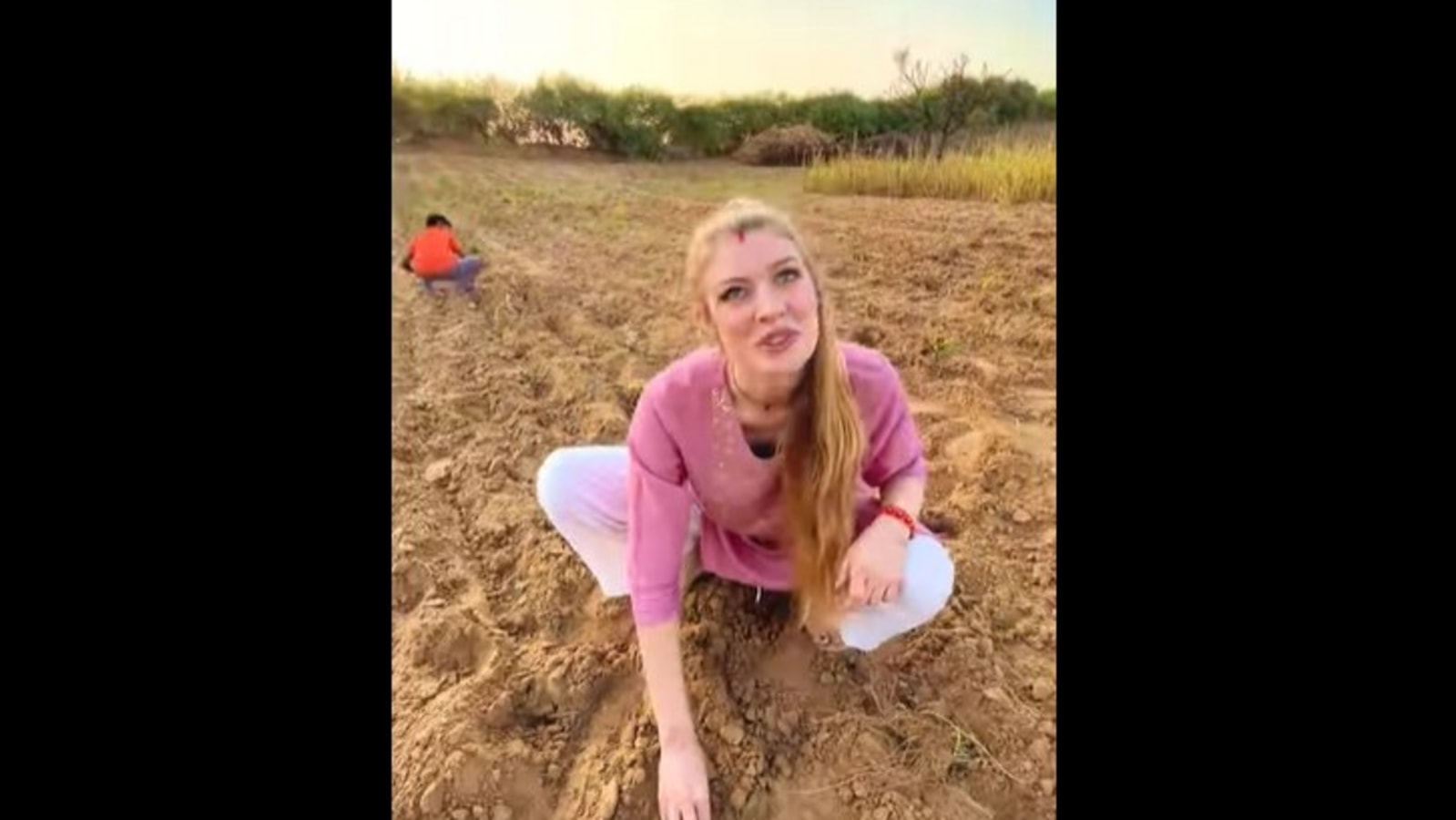 German woman plants onions in a farm with her Indian mother-in-law. Watch